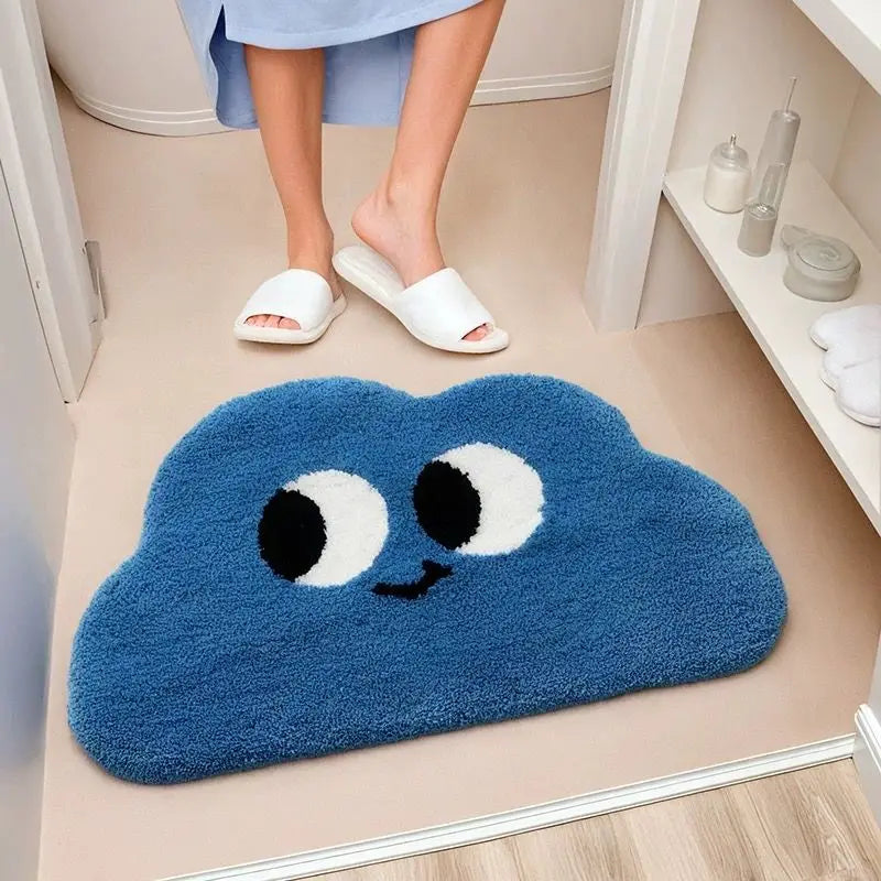 Blue cloud-shaped bath mat with a Kawaii face on a bathroom floor.