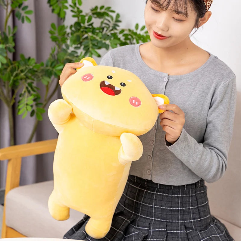 Person holding a large yellow kawaii plush toy with a happy expression indoors.