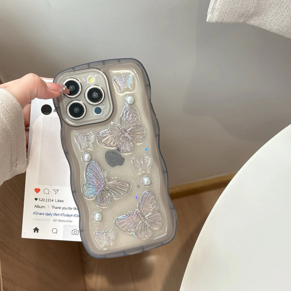Phone case with kawaii butterfly design held by a hand against a neutral background