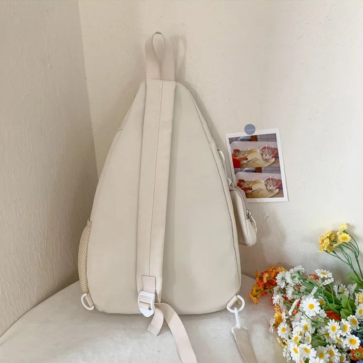 Beige Kawaii backpack on a white surface with flowers and a photo in the background