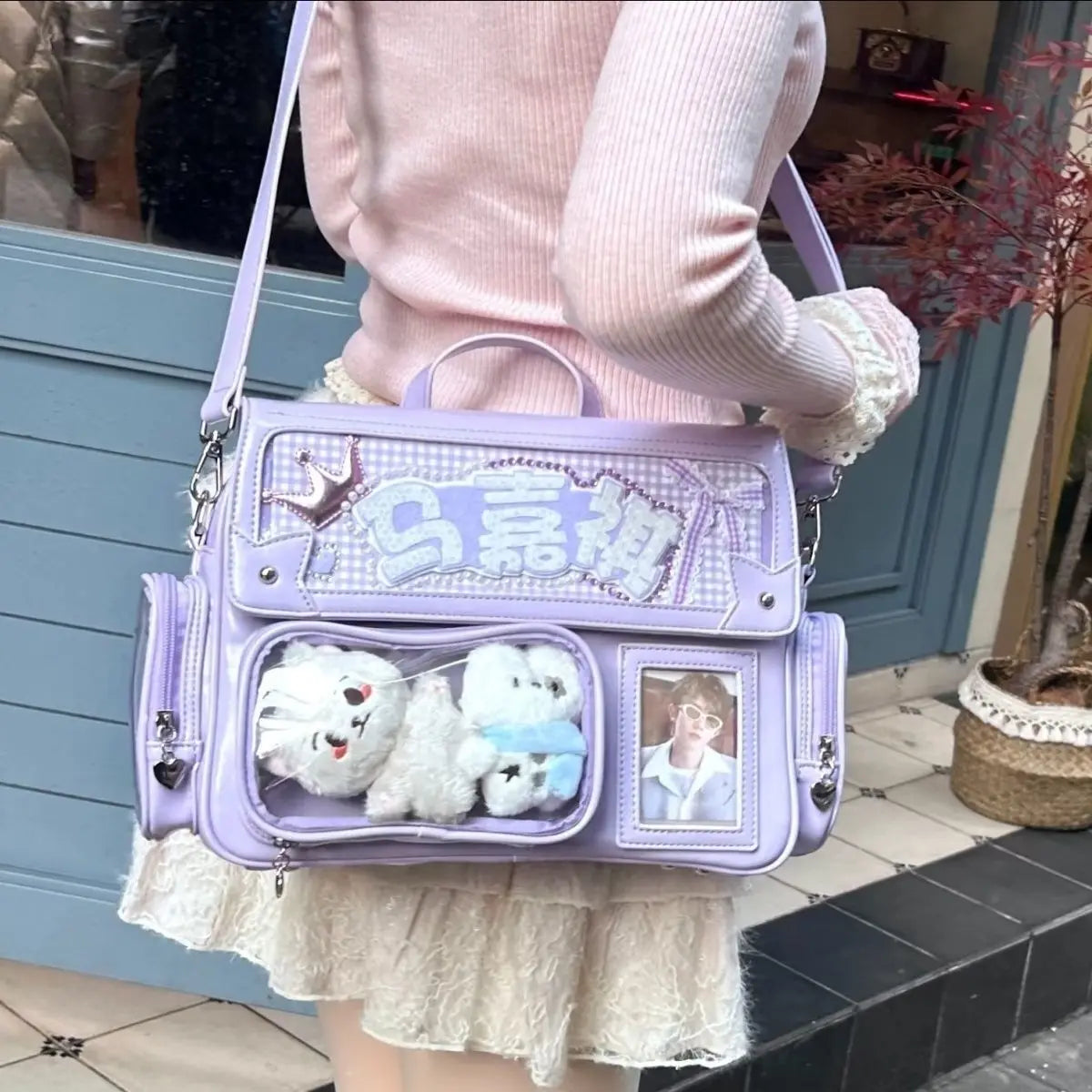 Person holding a purple Kawaii handbag with decorative elements and stuffed toys.