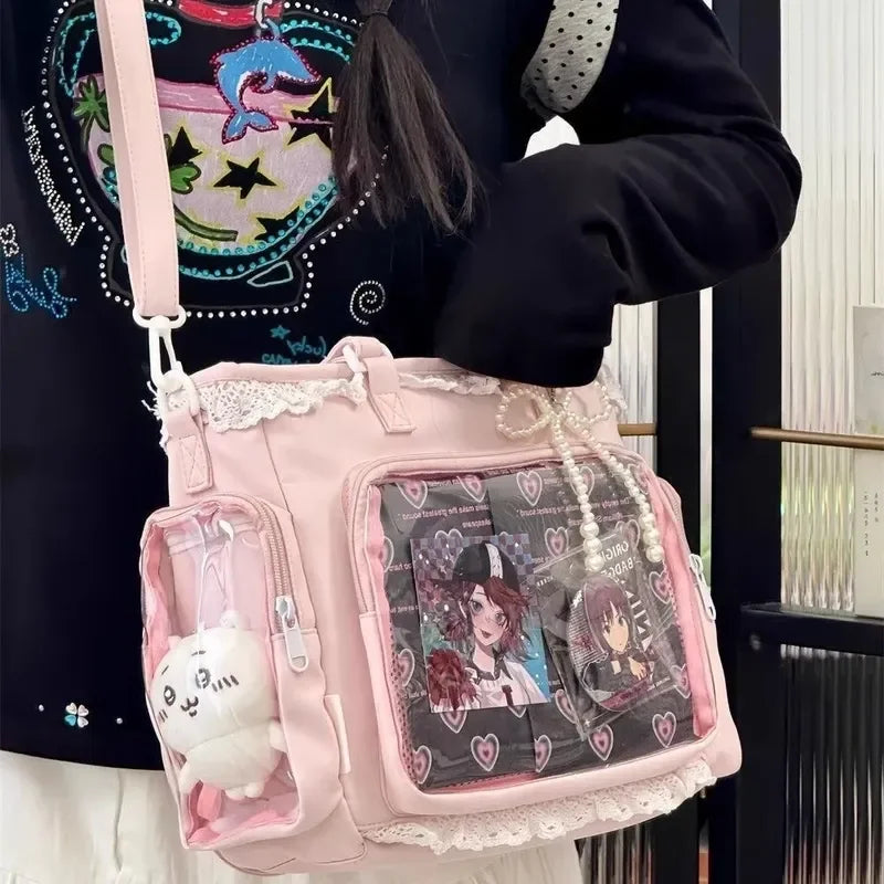 Pink Kawaii handbag with anime-themed design held by a person wearing a black sweater.