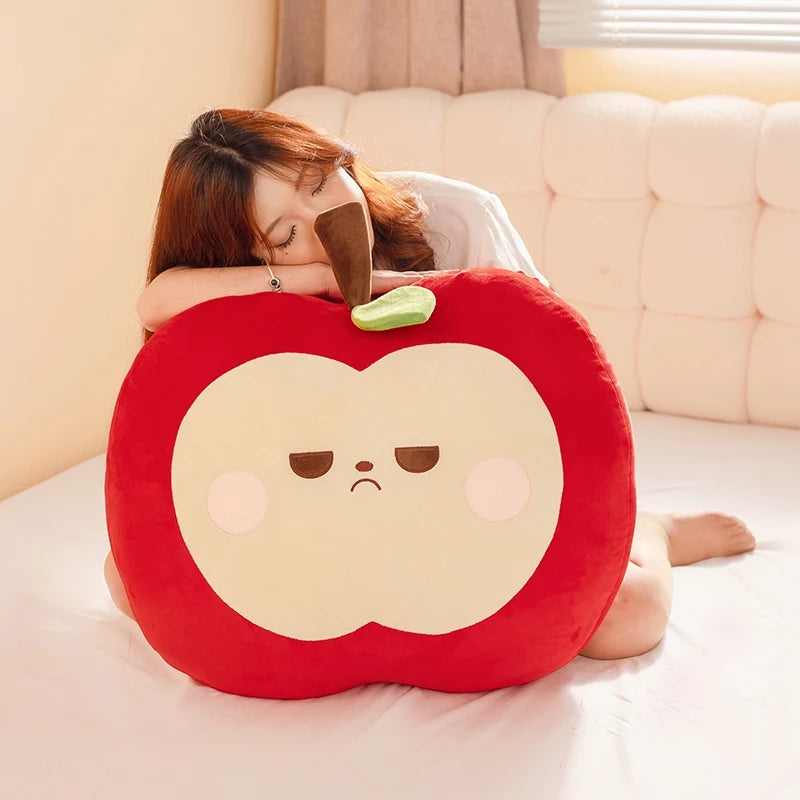 Person lying on a bed with a red kawaii apple-shaped pillow