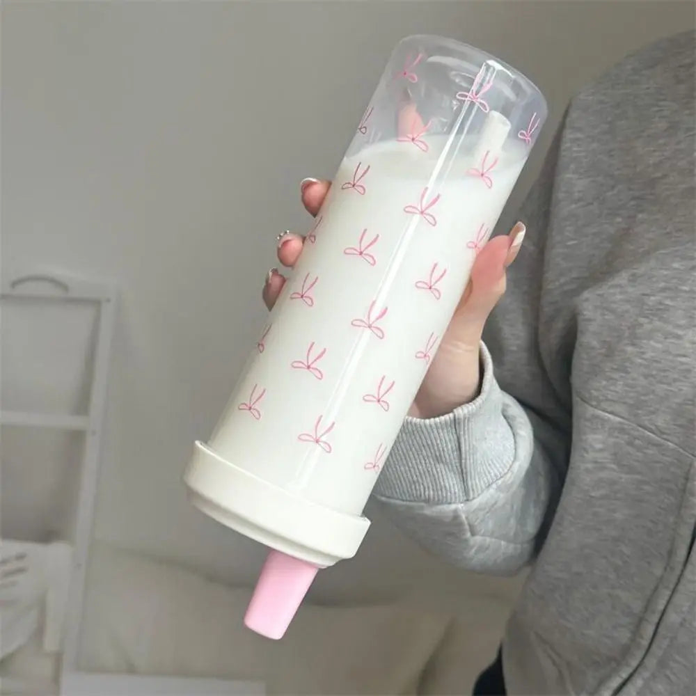 Person holding a cylindrical container with a Kawaii pink nozzle against a neutral background