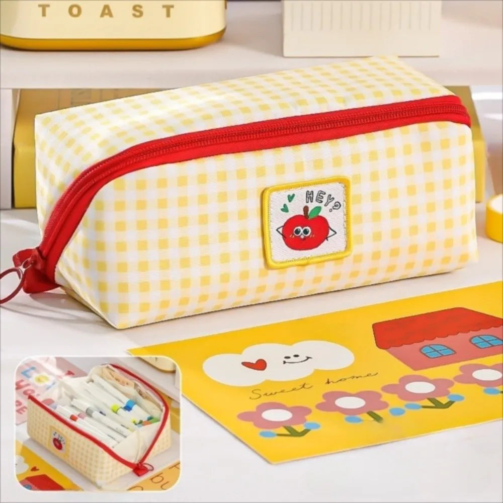 Yellow kawaii checkered pencil case with red zipper on a white surface