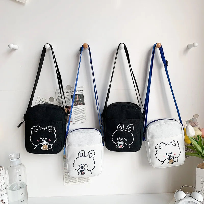 Four small bags with Kawaii cartoon designs hanging on a wall.
