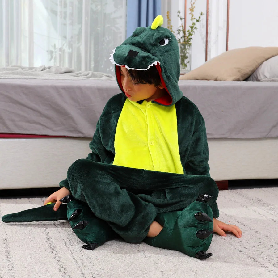 Child wearing a green kawaii dinosaur onesie sitting on a carpeted floor.