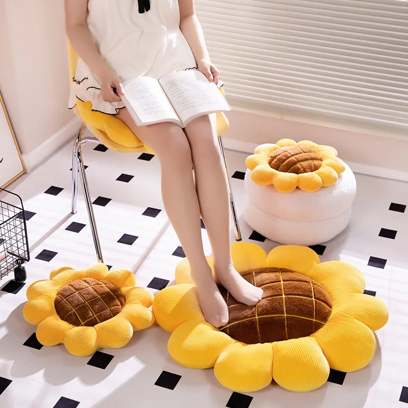 Sunflower-shaped kawaii cushions on a checkered floor with a person sitting on a chair.