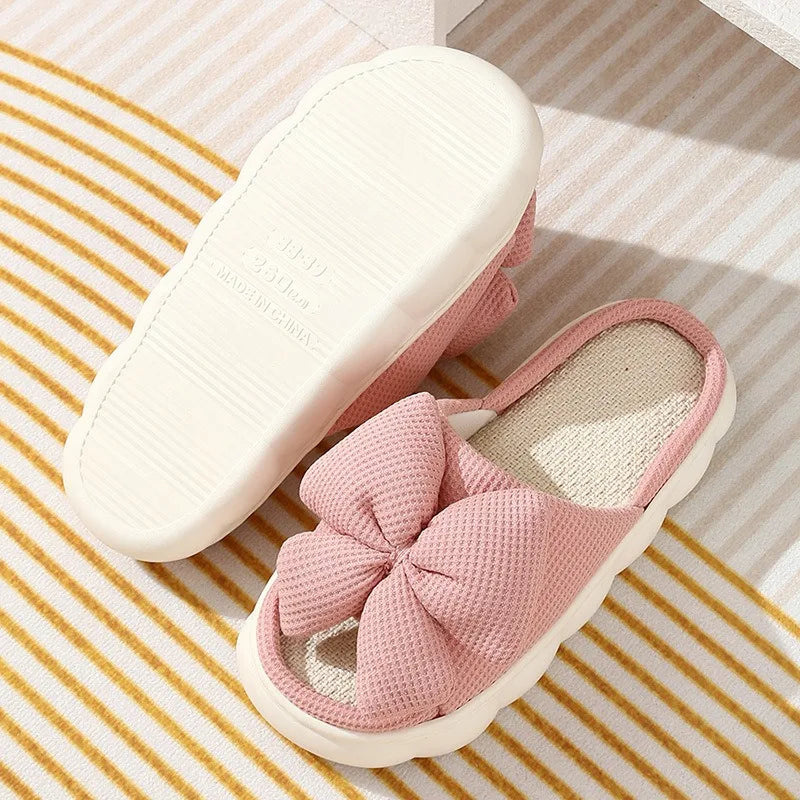 Pink slippers with a kawaii bow on a striped background