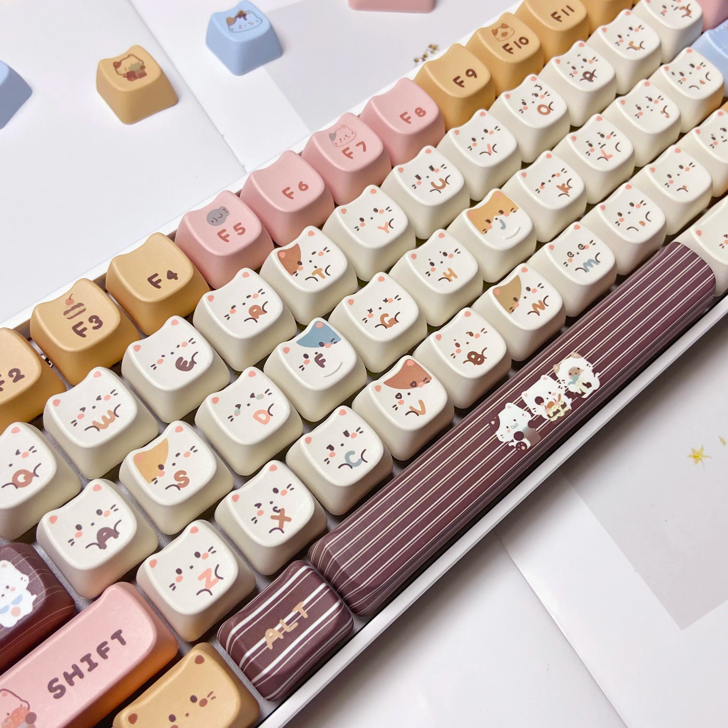 Set of Kawaii keycaps with animal designs on a white surface
