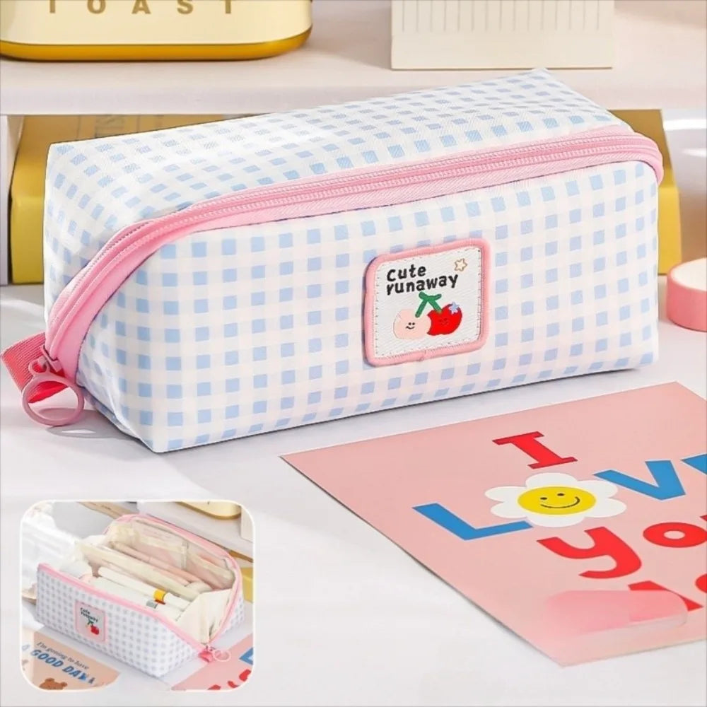 Checkered kawaii pencil case with pink zipper on a white surface