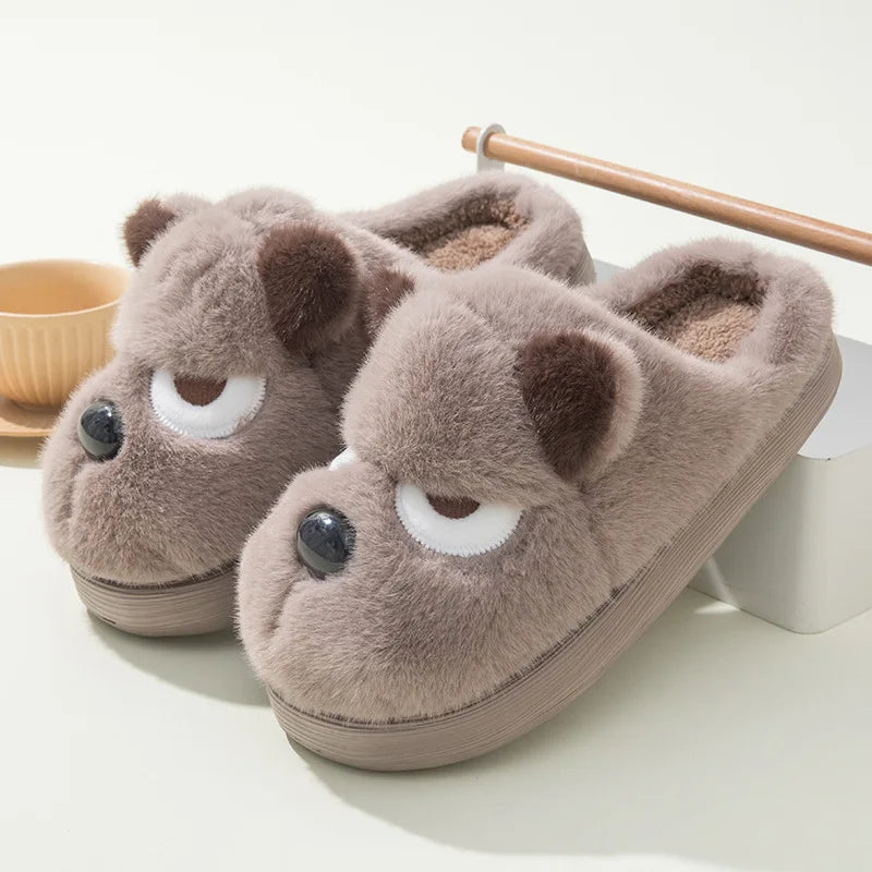 Pair of brown kawaii cartoon-style slippers with facial features on a white background