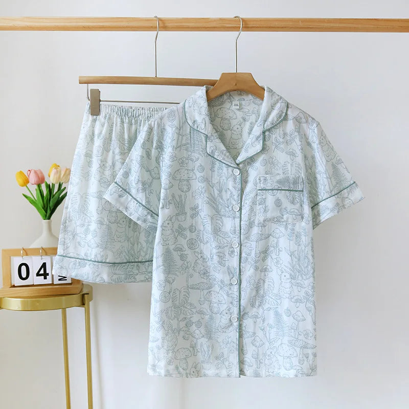 Light blue pajama set with kawaii floral pattern on a wooden hanger against a white wall.
