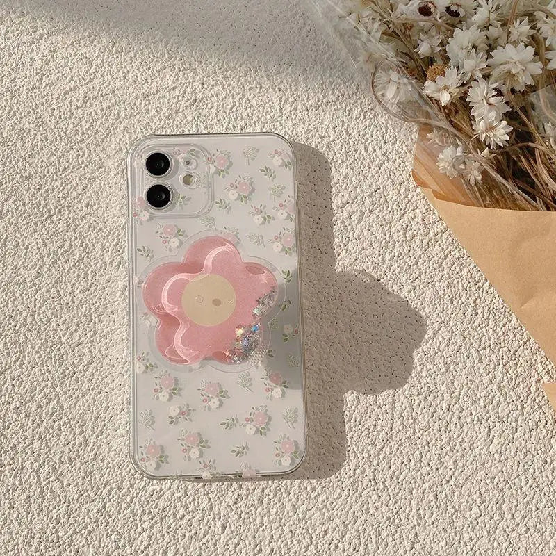 Phone case with a kawaii pink flower design on a textured surface with dried flowers.