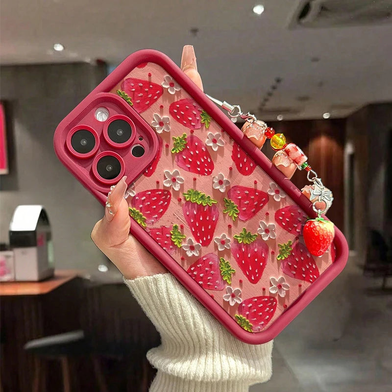 Phone case with kawaii strawberry design held by a person in a blurred indoor setting