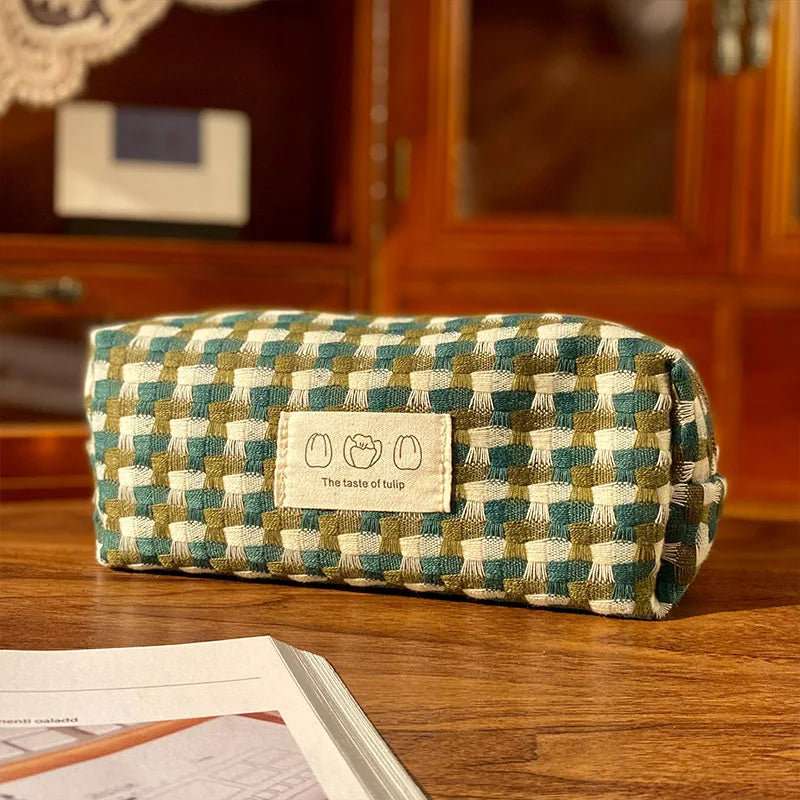 Checkered fabric kawaii pouch with a label on a wooden surface