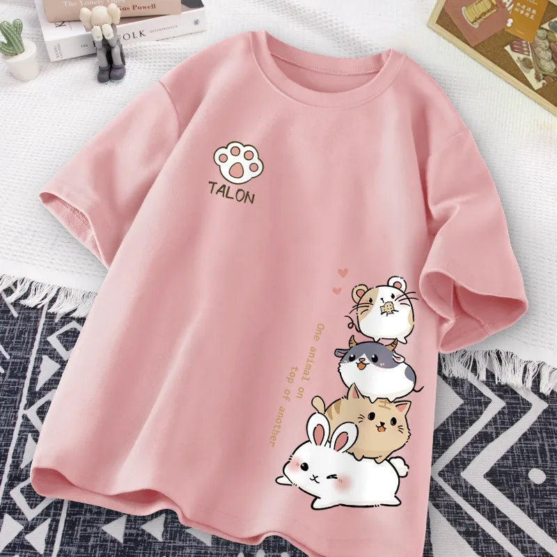 Pink t-shirt with kawaii cartoon animals and 'TALON' branding on a textured surface.