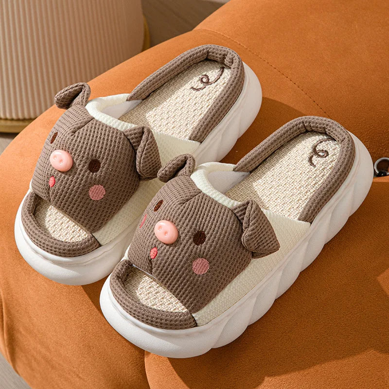Pair of brown kawaii slippers with pink accents on a brown surface