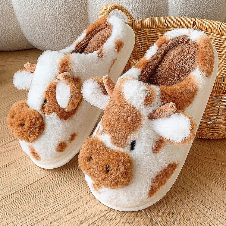 Pair of plush slippers with kawaii animal design on a wooden floor.