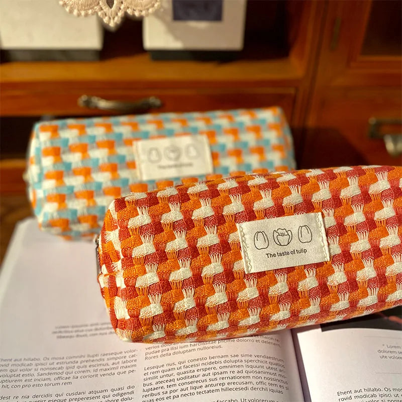 Two patterned kawaii pouches on an open book with a visible brand label.