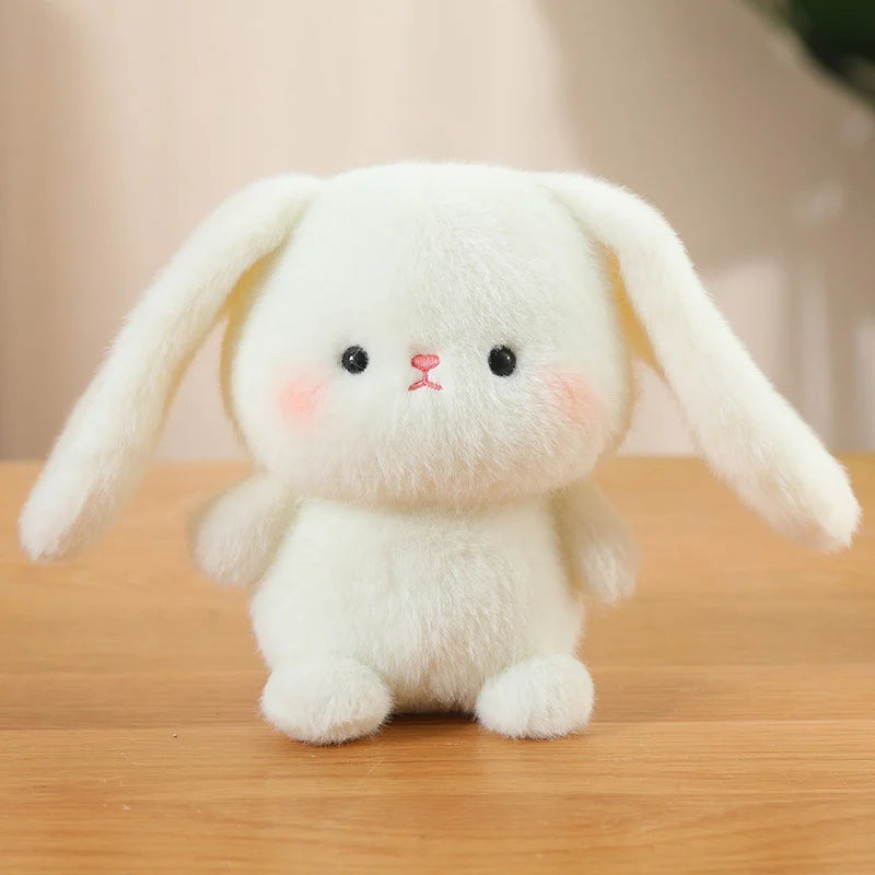 White plush bunny kawaii toy on a wooden surface with a blurred background