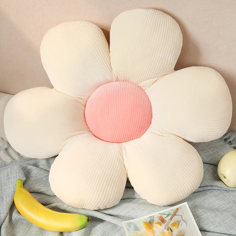 Flower-shaped Kawaii cushion with a pink center on a soft surface with bananas and a magazine.