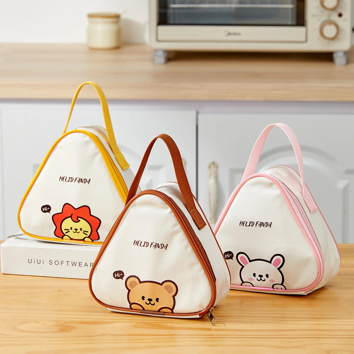 Three triangular bags with kawaii cartoon designs on a kitchen counter