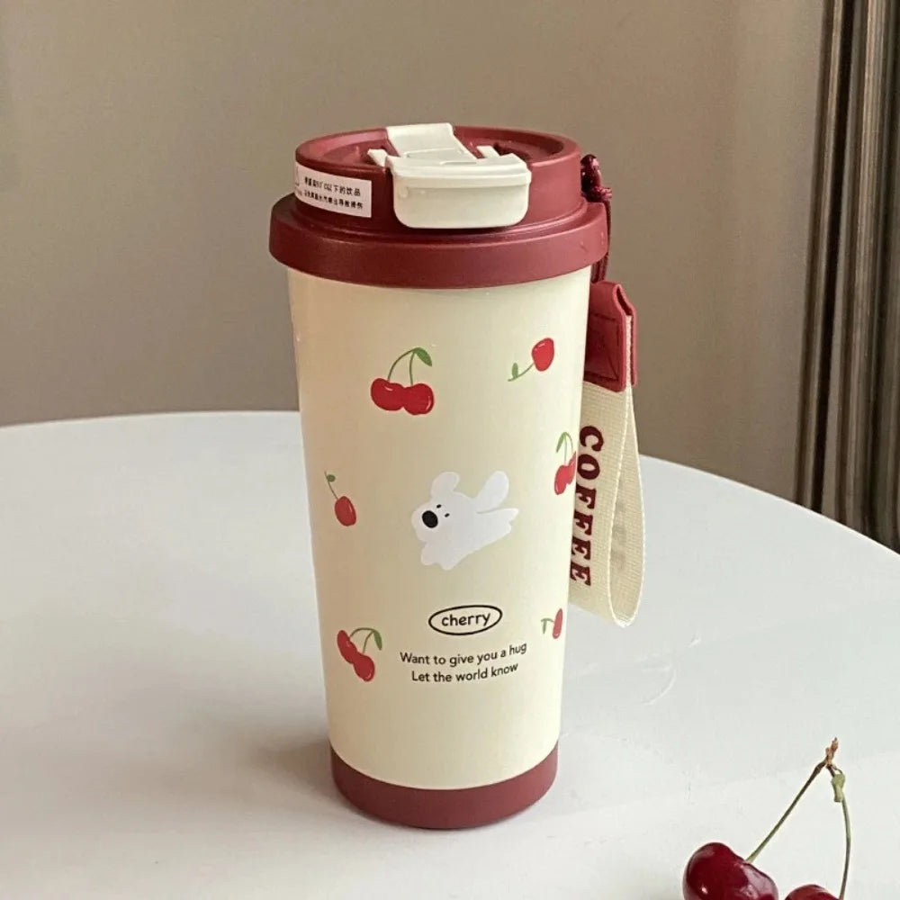 Travel mug with Kawaii cherry and dog design on a white surface