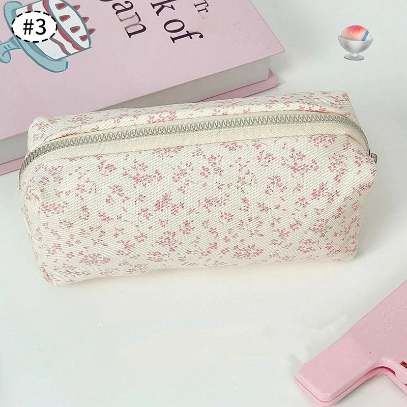 Floral-patterned kawaii pencil case on a light surface with a book and stationery items.