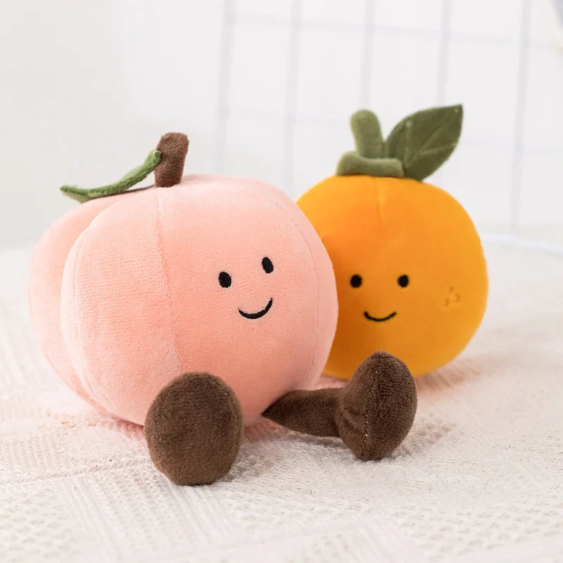 Two kawaii plush pumpkins, one pink and one orange, on a white background