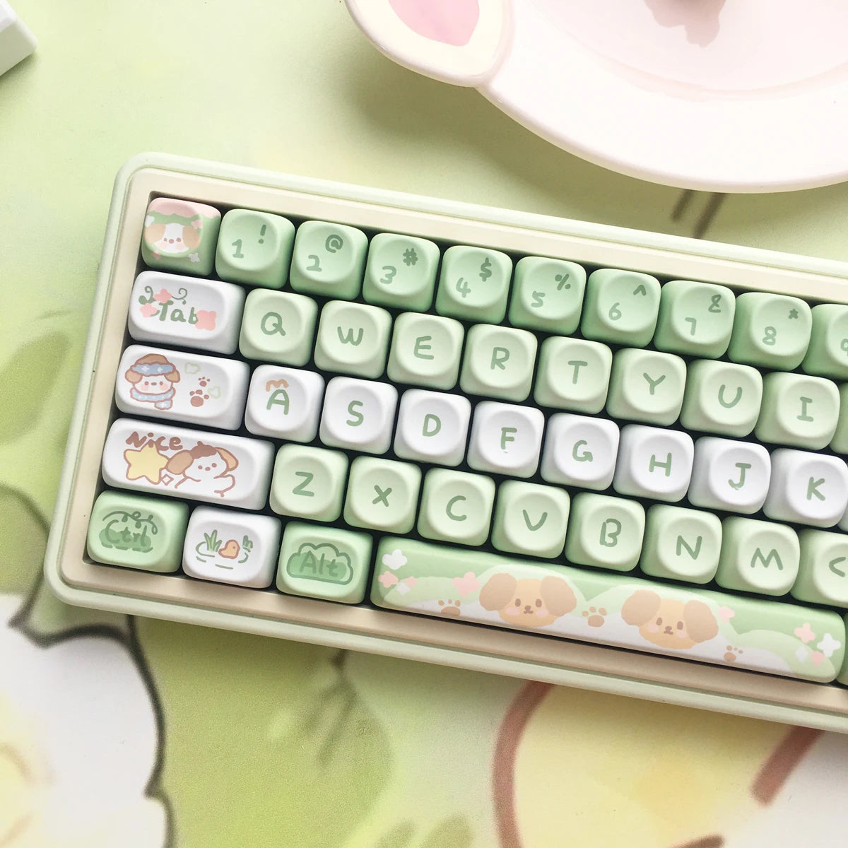 Small keyboard with Kawaii, cartoonish keycaps on a light green surface.