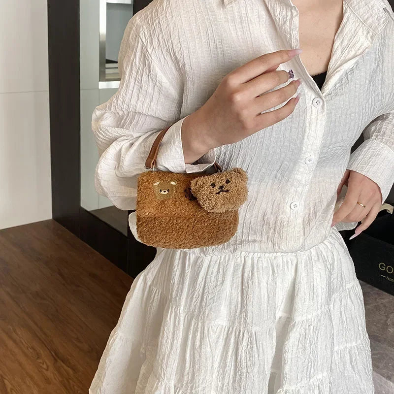 Person wearing a white outfit with a Kawaii brown fuzzy bag featuring a bear face.