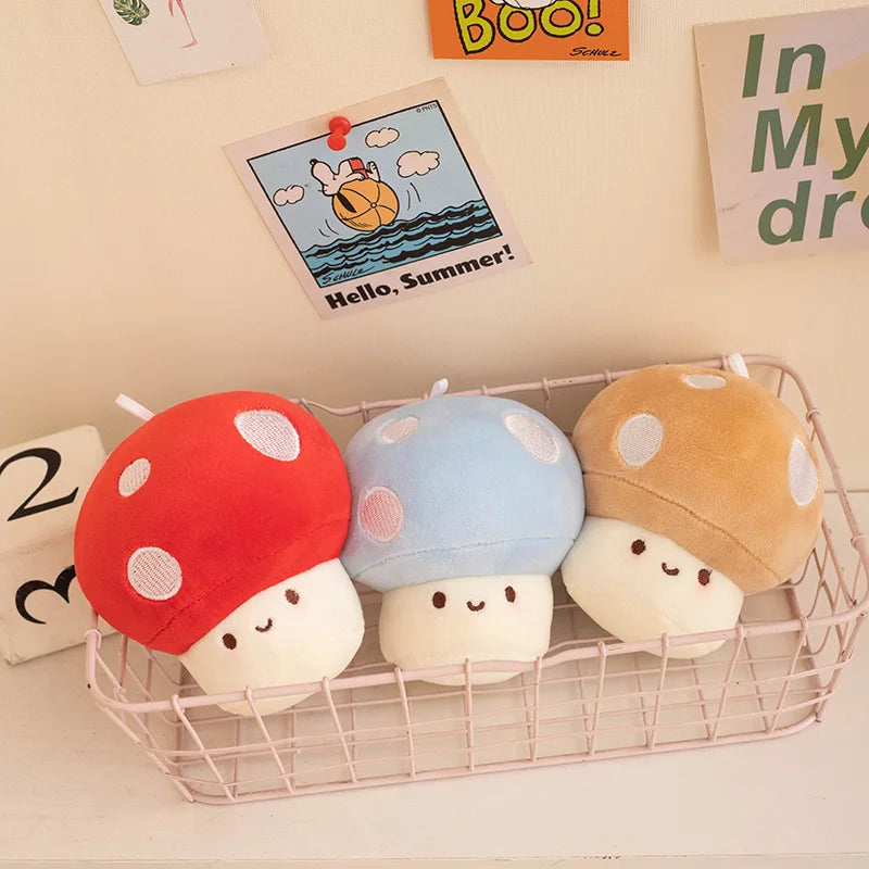 Three kawaii colorful mushroom-shaped plush toys in a wire basket with decorative items in the background.