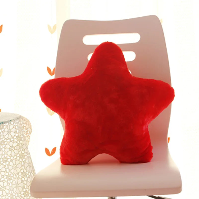 Red star-shaped Kawaii pillow on a chair with a blurred background