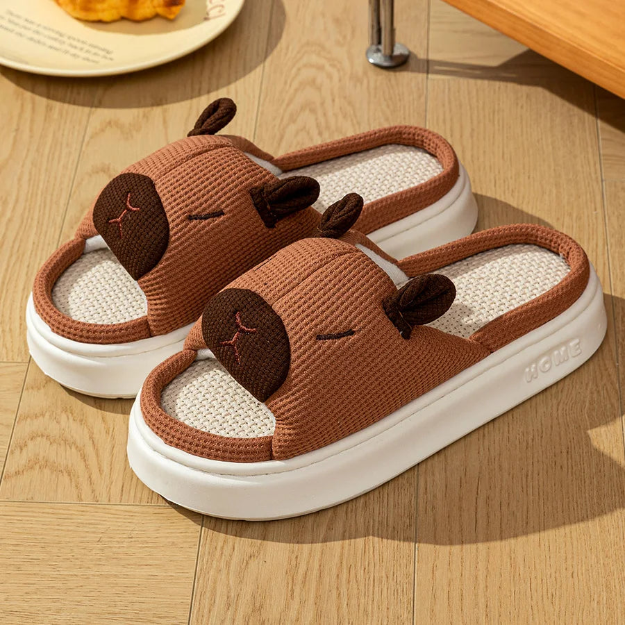 Brown kawaii capybara-shaped slippers on a wooden floor
