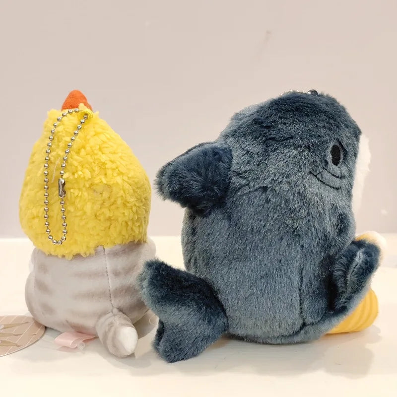 Two kawaii plush toys, one yellow and one gray, on a light background