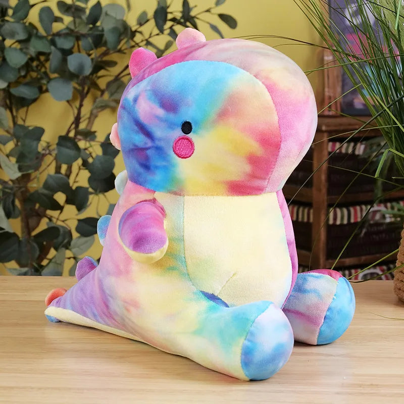 Colorful tie-dye kawaii plush toy on a wooden surface with plants in the background