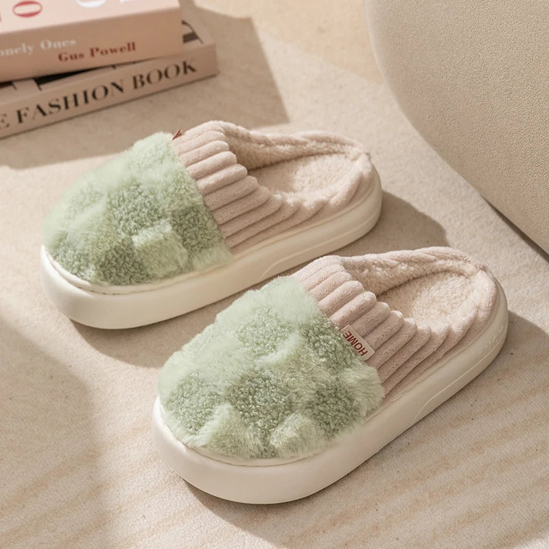 Pair of light green kawaii slippers on a beige surface with books in the background