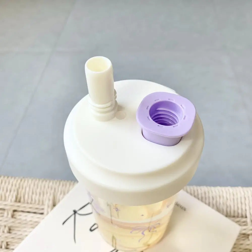 White Kawaii tumbler with a purple silicone lid on a light gray background