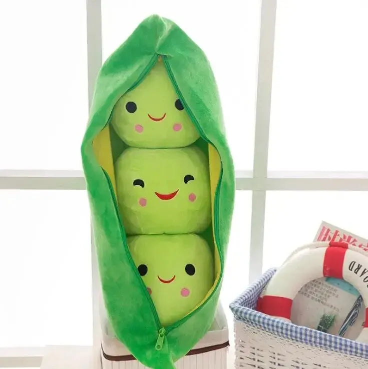Kawaii plush toy of three green peas in a pod with a smiling face on a white surface.