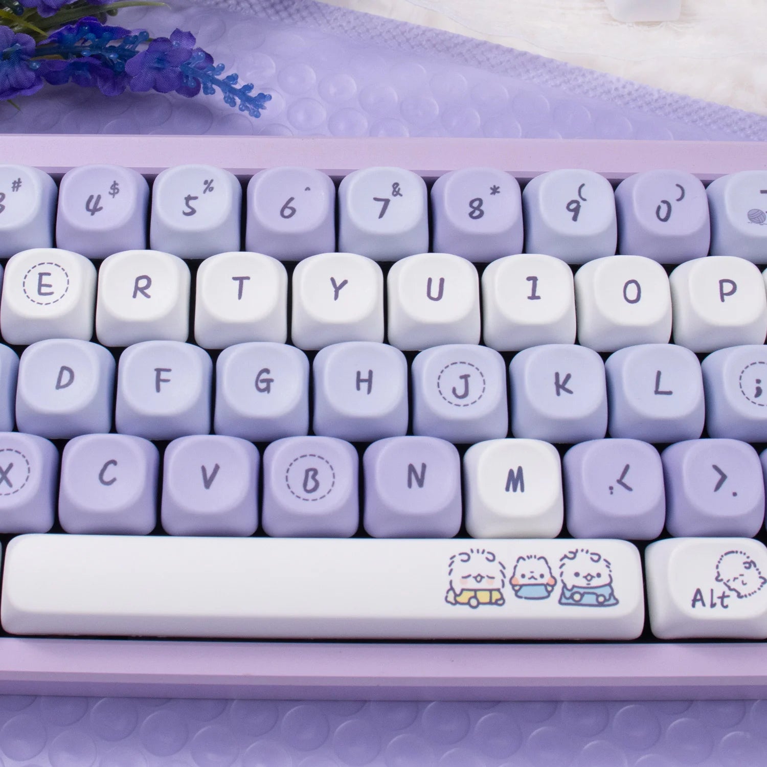 Purple and white Kawaii keyboard with cute character designs on the space bar