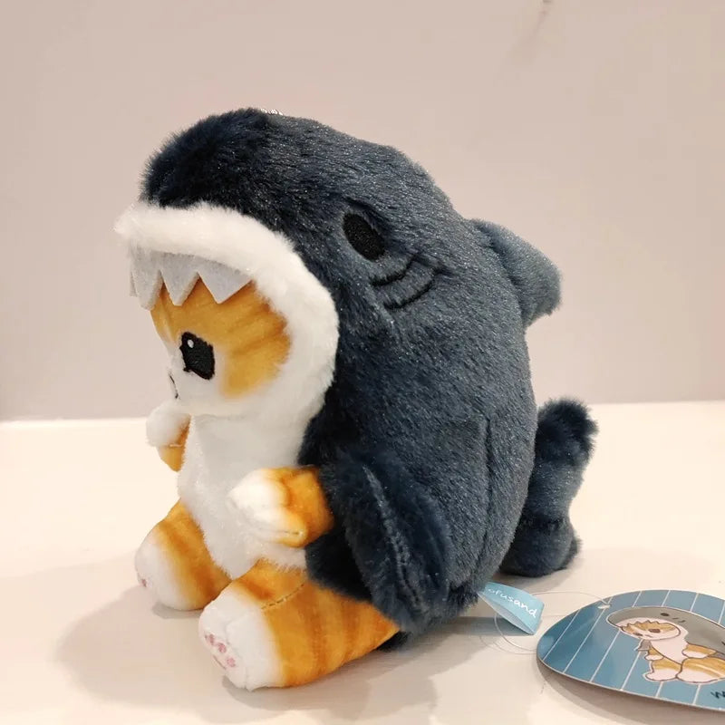 Plush kawaii toy resembling a shark with a cat body on a white surface