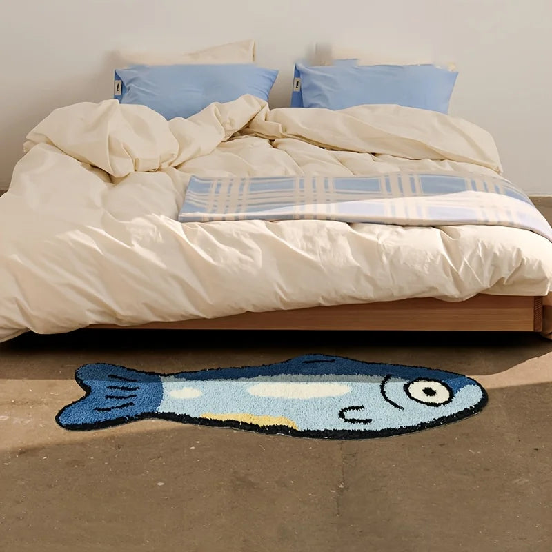 Fish-shaped kawaii rug on the floor in front of a bed with white bedding and blue pillows.