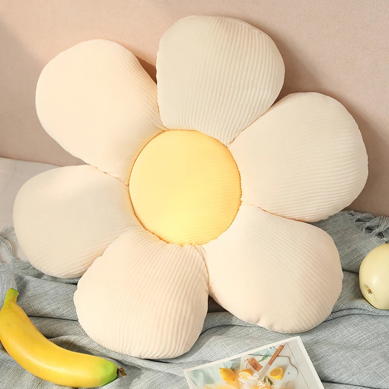 Kawaii flower-shaped pillow with a yellow center on a soft surface with bananas and a magazine.