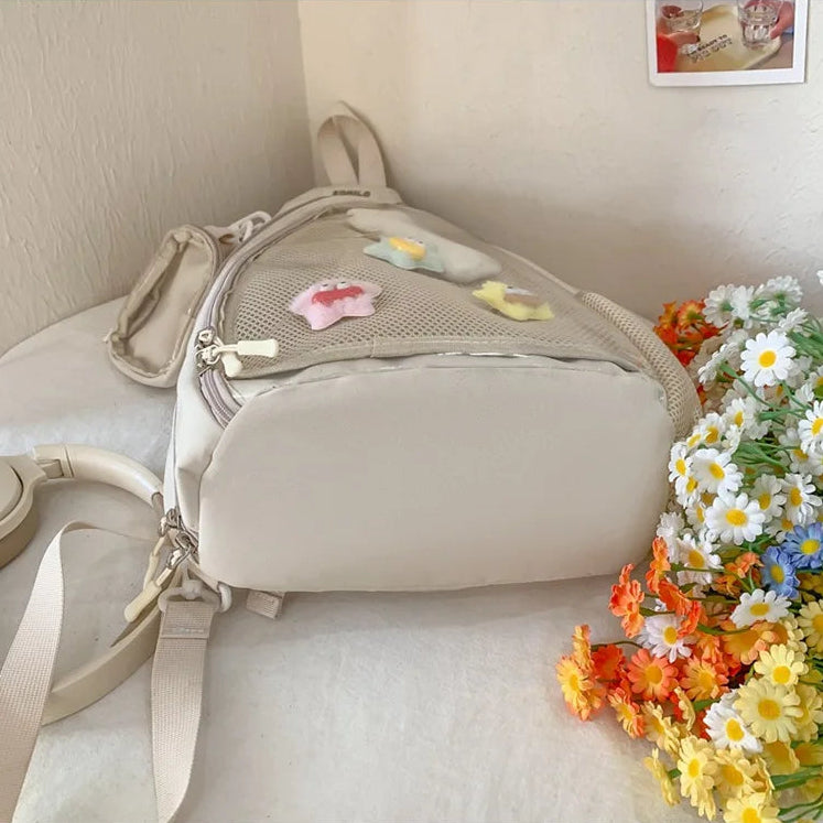 Beige Kawaii backpack with decorative elements on a white surface with flowers