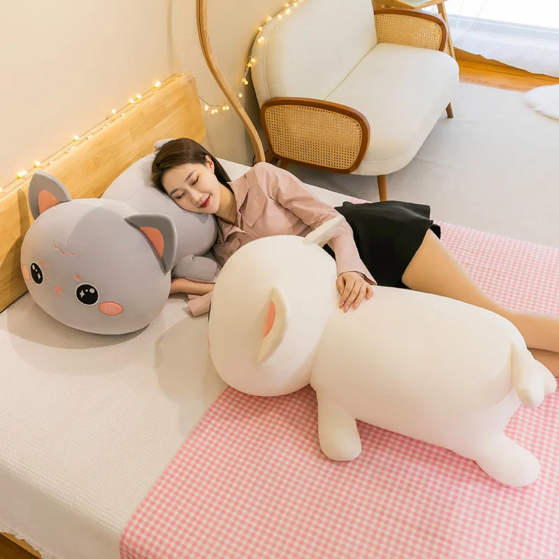 Woman lying on a bed with large cat-shaped kawaii cushions