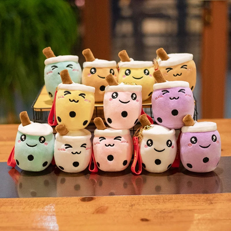 Stack of colorful kawaii plush toys resembling bubble tea cups on a wooden surface.