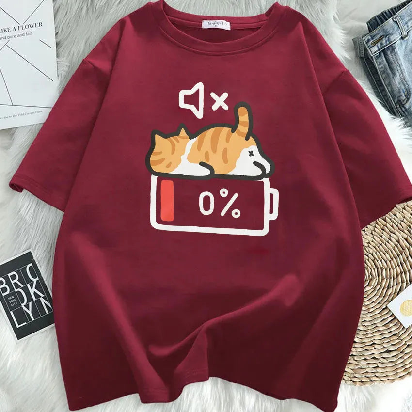 Maroon t-shirt with a kawaii graphic of a cat and battery symbol on a textured surface.