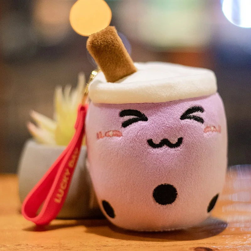 Plush toy resembling a bubble tea with a kawaii smiley face on a wooden surface.