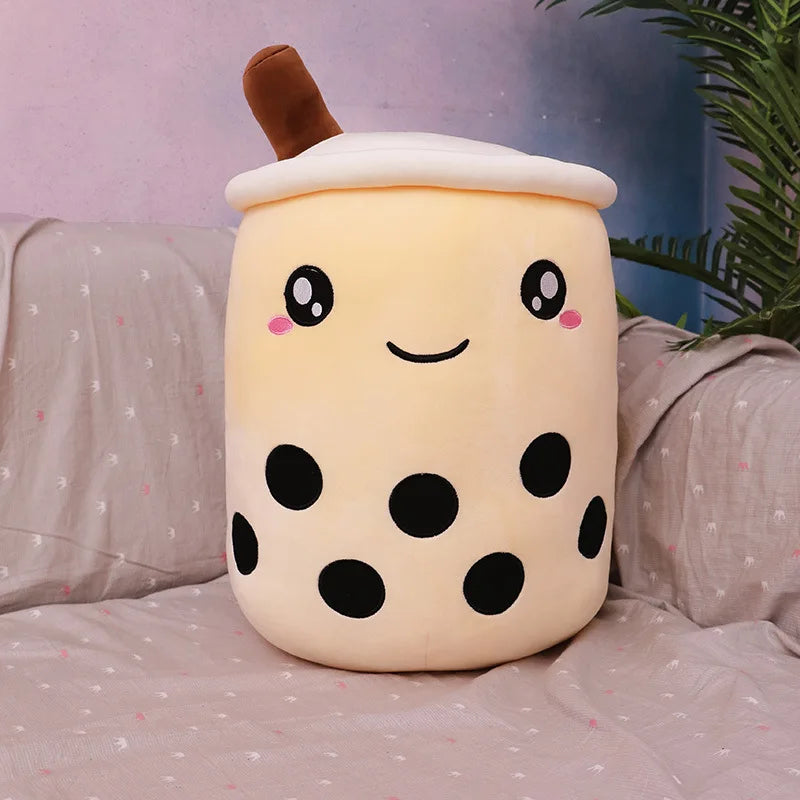 Cute kawaii plush toy resembling a bubble tea cup on a bed